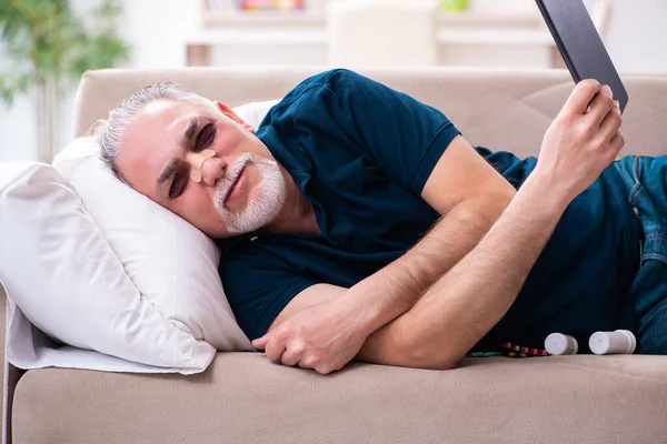 Velho com os olhos feridos descansando em casa — Fotografia de Stock