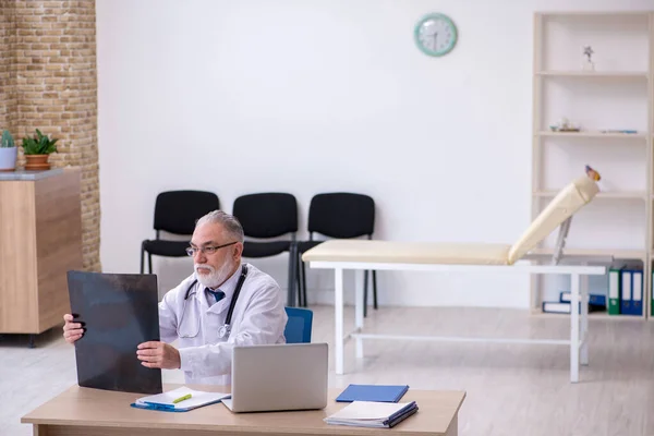 Gammal manlig läkare som arbetar på kliniken — Stockfoto