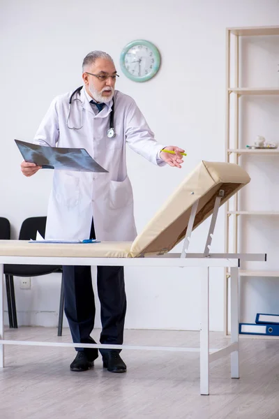 Oude mannelijke arts werkzaam in de kliniek — Stockfoto