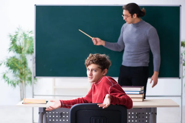 Jonge mannelijke leraar en schooljongen in de klas — Stockfoto