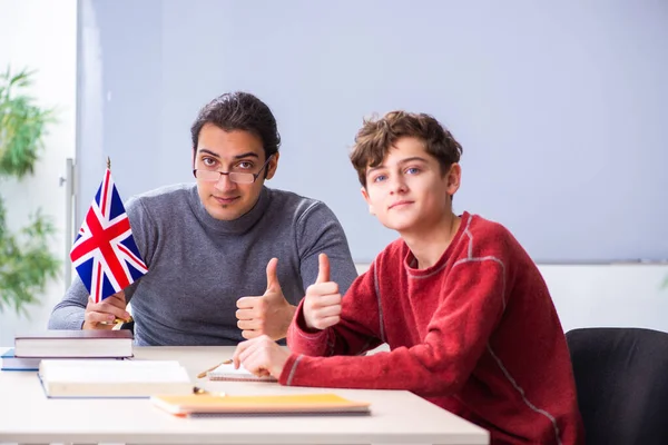 Jonge mannelijke leraar en schooljongen in de klas — Stockfoto