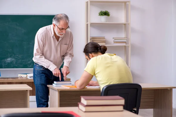 Vecchio insegnante e giovane studente maschio in classe — Foto Stock