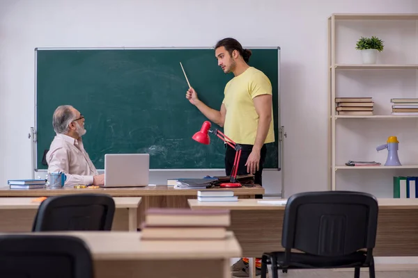 Oude leraar en jonge mannelijke student in de klas — Stockfoto