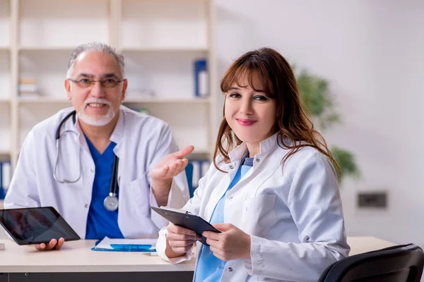 Gammal manlig läkare radiolog och hans unga kvinnliga assistent i th — Stockfoto