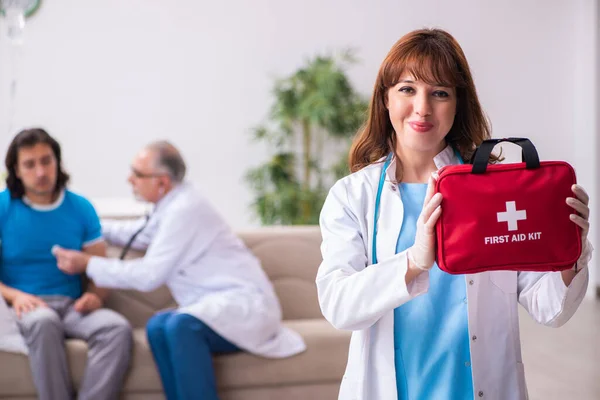 Zwei Ärzte besuchen kranken jungen Mann zu Hause — Stockfoto