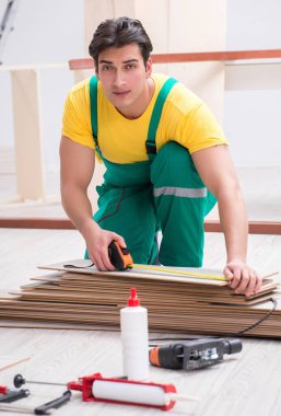 Müteahhit lamine ahşap zemin üzerinde çalışıyor.