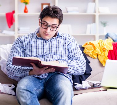 Genç adam dağınık bir odada çalışıyor.