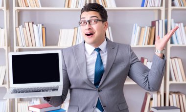 Kütüphanede çalışan boş ekran bilgisayarı olan bir iş adamı.