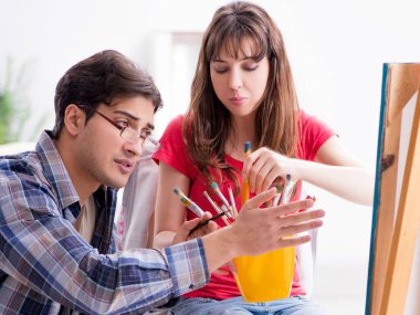 Stüdyoda resim sınıfında sanatçı koçluğu yapan bir öğrenci.