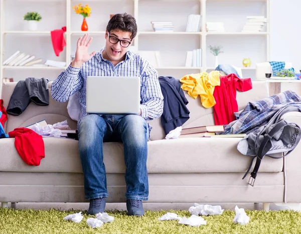 Jeune homme travaillant dans une chambre désordonnée — Photo