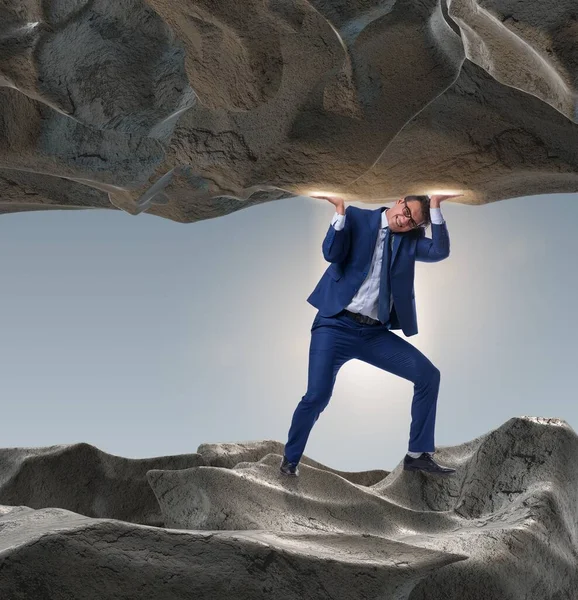 Businessman supporting stone under pressure