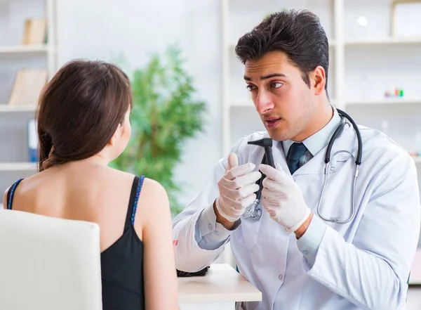 Doctor checking patients ear during medical examination