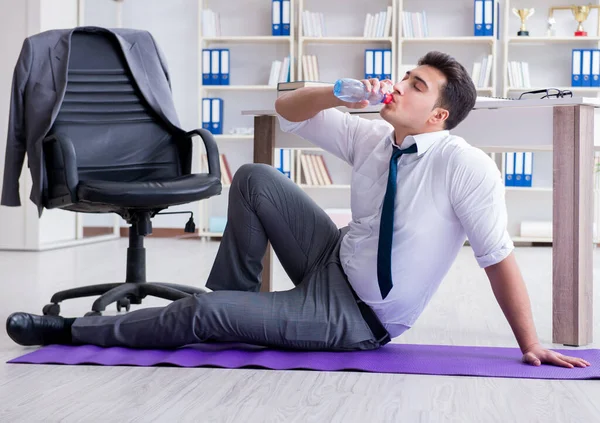 Geschäftsmann sitzt auf dem Boden und trinkt Wasser — Stockfoto