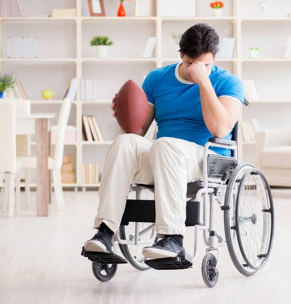 Jovem jogador de futebol americano se recuperando em cadeira de rodas — Fotografia de Stock