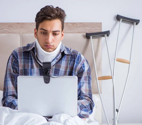 El hombre lesionado charlando en línea a través de la webcam en la cama en casa — Foto de Stock