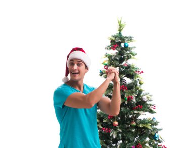 Genç adam beyaz üzerine izole edilmiş noel ağacını süslüyor.