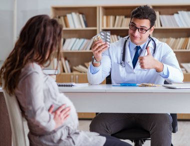 Hamile kadın muayene için doktoru ziyaret ediyor.