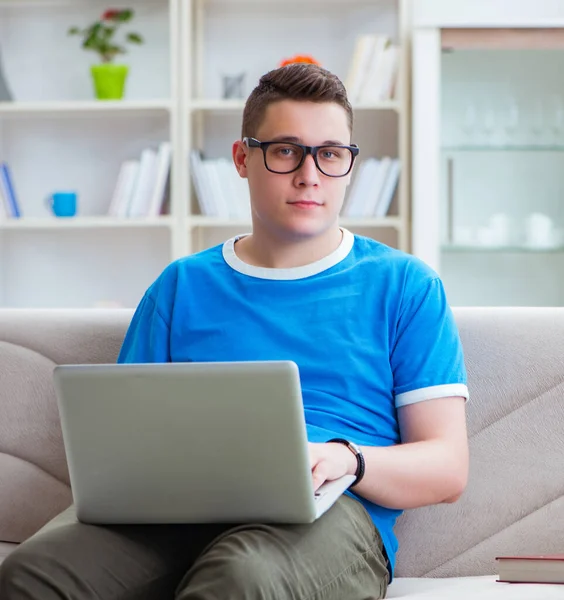 Ung student förbereder sig för tentor studera hemma i en soffa — Stockfoto