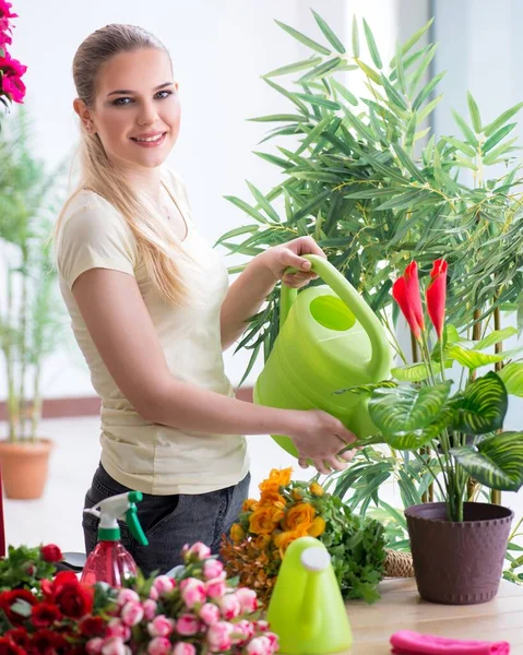 Ung kvinna vattna växter i sin trädgård — Stockfoto