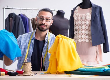 Yeni tasarımlar üzerinde çalışan erkek terzi.