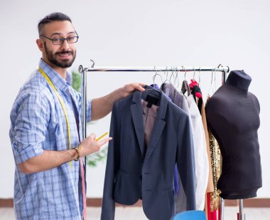 Yeni tasarımlar üzerinde çalışan erkek terzi.