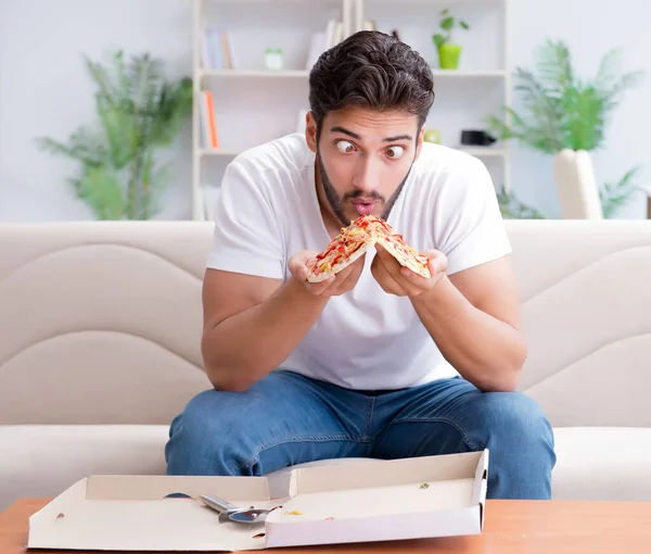 Hombre comiendo pizza teniendo una comida para llevar en casa descansando relajado — Foto de Stock