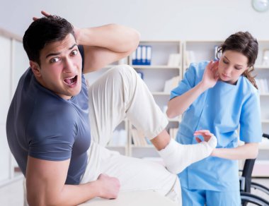 Hastanede yaralanma kontrolü sırasında doktor ve hasta.