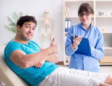 Doktor çekiçle sinir reflekslerini kontrol ediyor