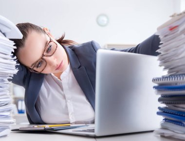 Evrak işleriyle uğraşan yorgun bir iş kadını.