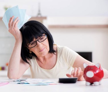 Faturalarını ödemeye çalışan olgun bir kadın.
