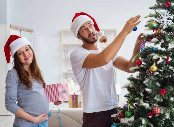 Jeune famille attend bébé célébrant Noël — Photo