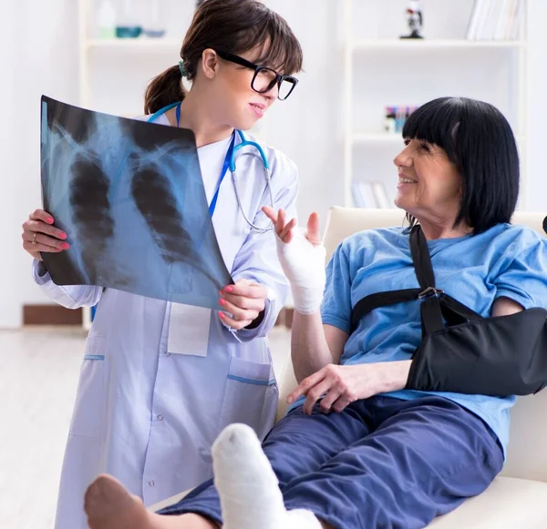 Doktor olaydan sonra yaşlı kadını muayene ediyor. — Stok fotoğraf