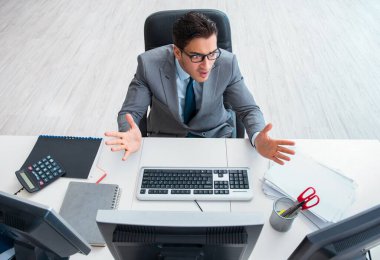 Genç işadamı masasında çalışıyor.