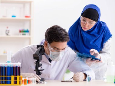 Laboratuvarda çalışan iki kimyager.