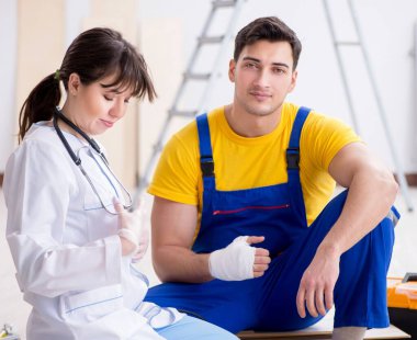 Yaralı işçiye doktor yardım ediyor.