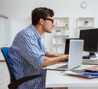 Birçok ekranın önünde oturan bir iş adamı