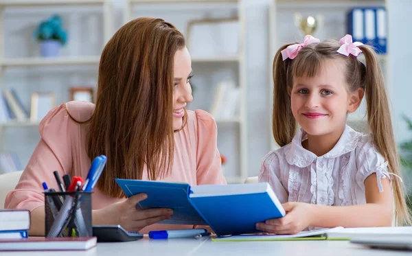 Mother helping her daughter to do homework — Stock Photo, Image