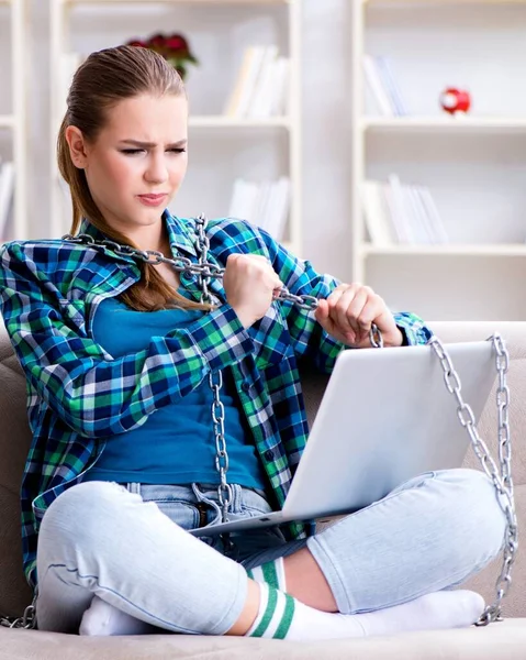 Spoutaná studentka s laptopem sedící na pohovce — Stock fotografie