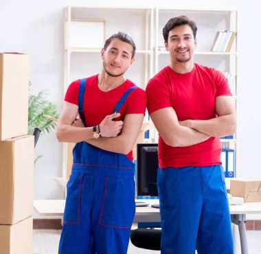 İki müteahhit personel kişisel eşyalarını taşıyor.