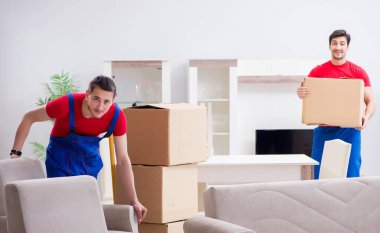 İki müteahhit personel kişisel eşyalarını taşıyor.