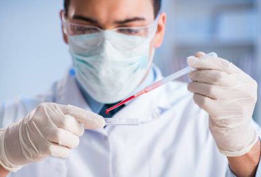 Laboratuvar asistanı hastanede kan örneklerini test ediyor.