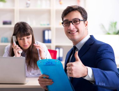 İş adamı doktorla sağlık sorunlarını tartışıyor