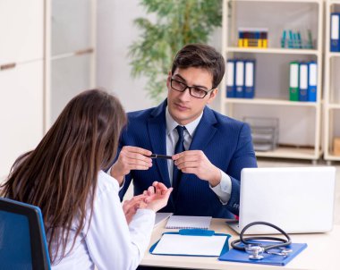 İş adamı doktorla sağlık sorunlarını tartışıyor