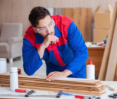 Yooung marangoz boyayla uğraşıyor.