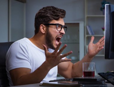 Genç adam fazla mesai yapmak için geç saatlere kadar ofiste kalıyor.