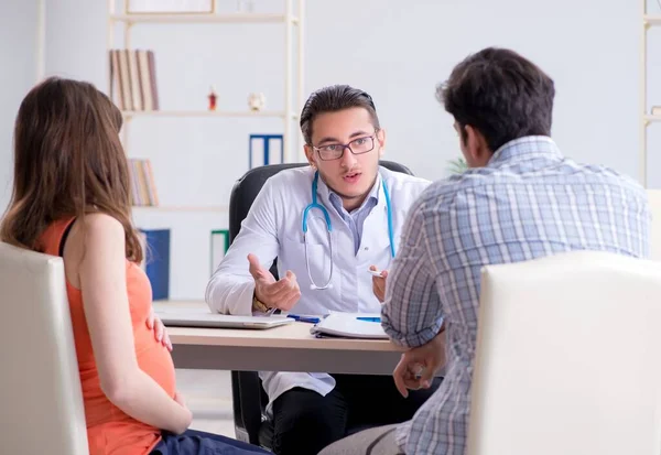 Mujer embarazada con su marido visitando al médico en la clínica — Foto de Stock