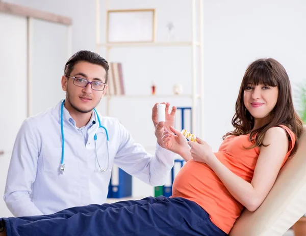 Hamile kadın kocasıyla klinikteki doktoru ziyaret ediyor. — Stok fotoğraf