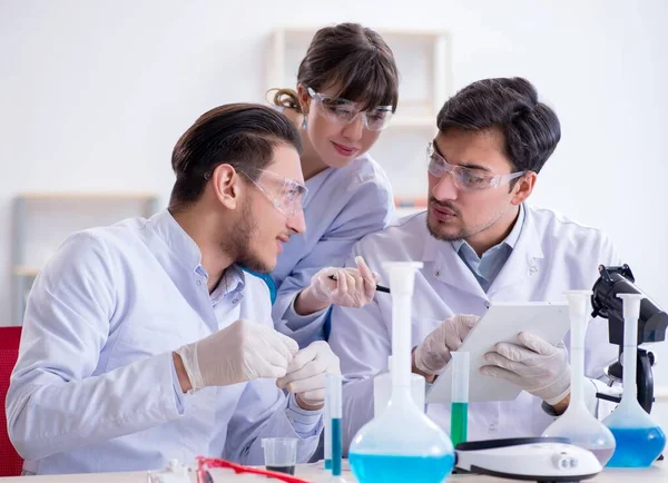 Equipe de químicos que trabalham no laboratório — Fotografia de Stock