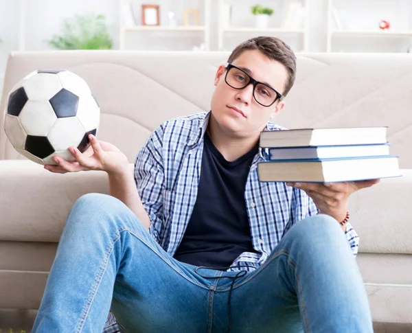 Jovem estudante tentando equilibrar estudar e jogar futebol — Fotografia de Stock