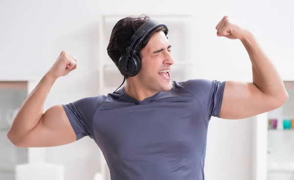 Adam evde spor yapıyor ve müzik dinliyor. — Stok fotoğraf